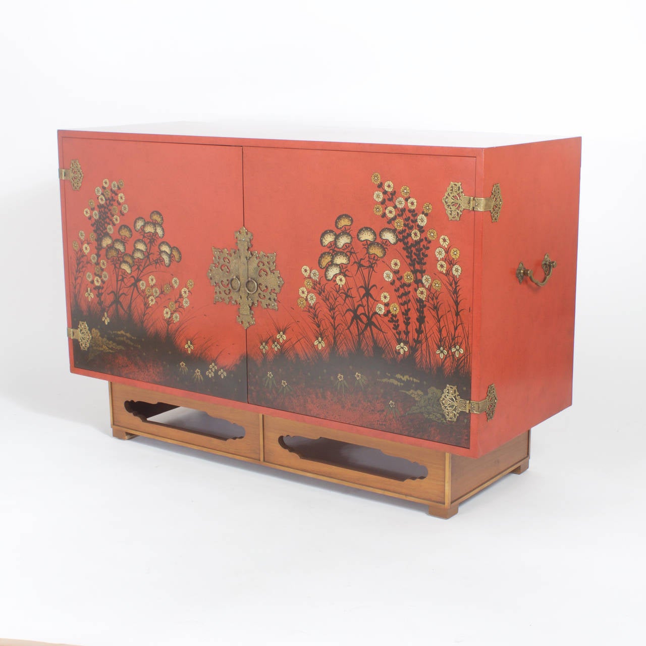 Mid Century red lacquer cabinet with 2 doors and plenty of storage. Perfect for under your flat screen television or to be used as a sideboard or server. Featuring brass Asian modern hardware and Asian style base with the cabinet front decorated in