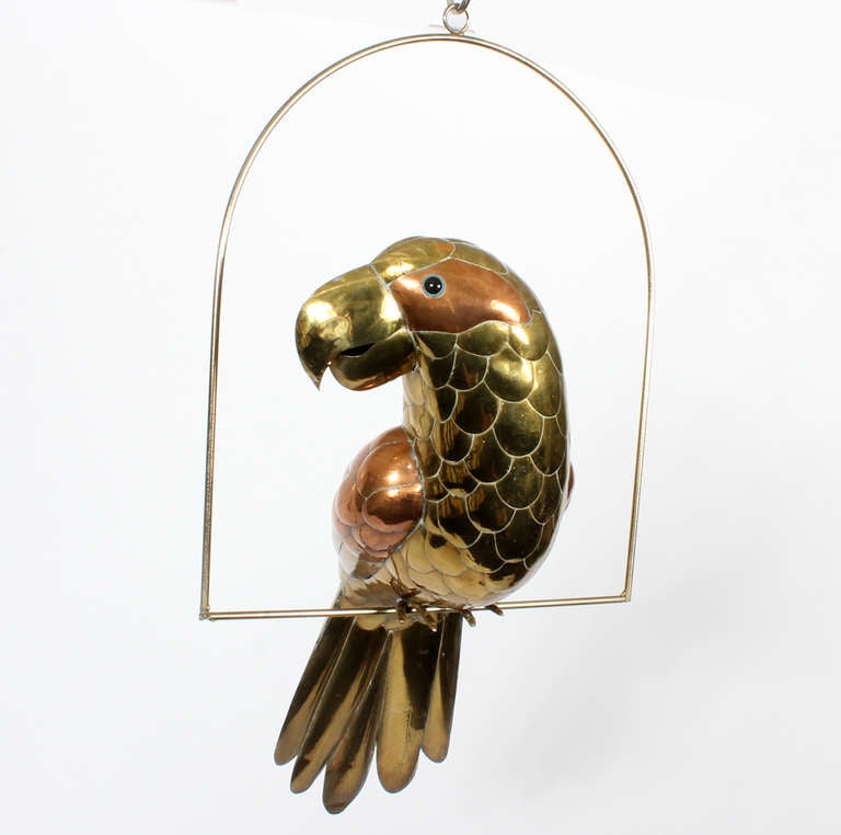 A fanciful brass and copper parrot sculpture perched on a brass hoop. Probably by Bustamante.

