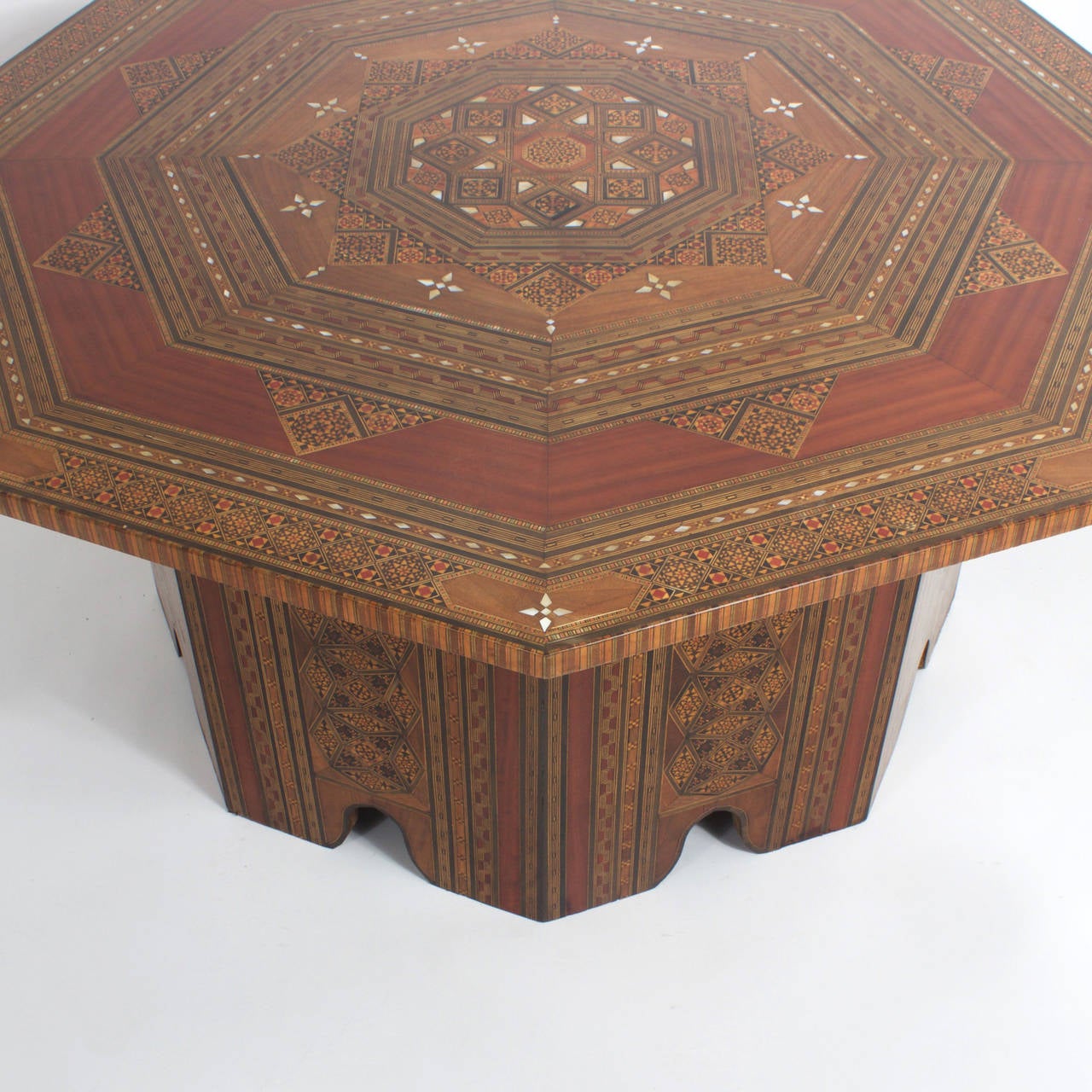 Important Syrian coffee table or cocktail table having an octagonal top with marquetry and inlays of exotic woods, bone and mother of pearl in geometric shapes. All 8 sides of the base with Marquetry and Architectural arches. Large scale makes this