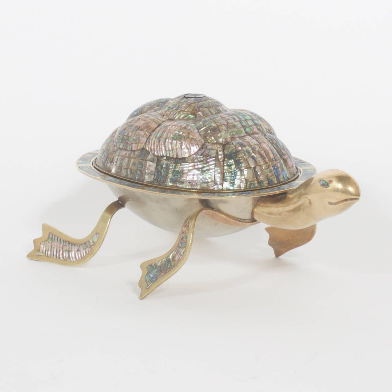 Delightful covered serving bowl in the shape of a turtle made of brass and silvered metal. The lid and sections of the legs are in an unexpected sophisticated Abalone mosaic. The lid handle is retractible yet easy to use. Form and function at its