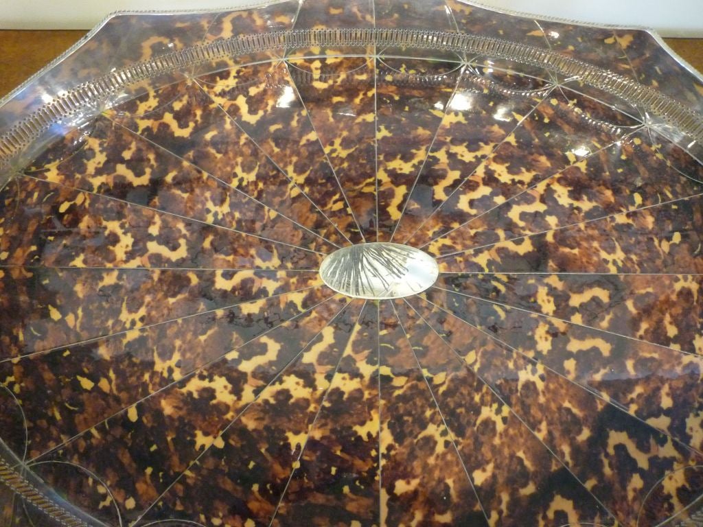 A large silver plated faux tortoise shell serving tray, with a pierced undulating gallery, and large turned feet.