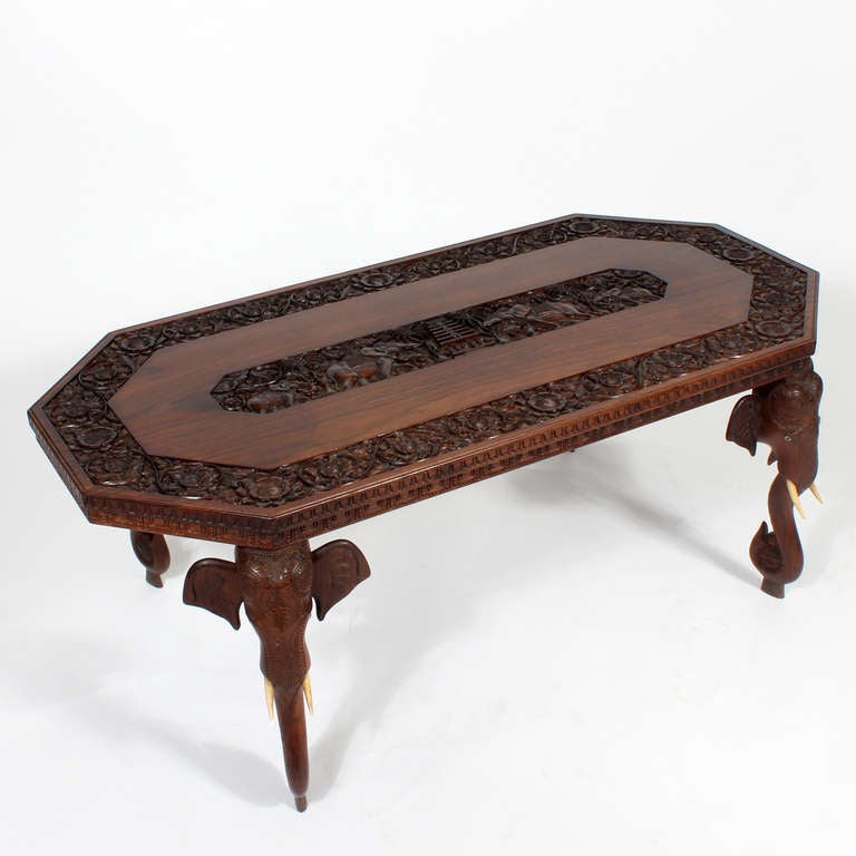 A well carved Anglo Indian low table or cocktail table, with elephant head legs and full bodied elephant, temple and palm tree carvings. Exceptional deep detailed carving.

All pieces at FS Henemader are professionally examined, and any issues are