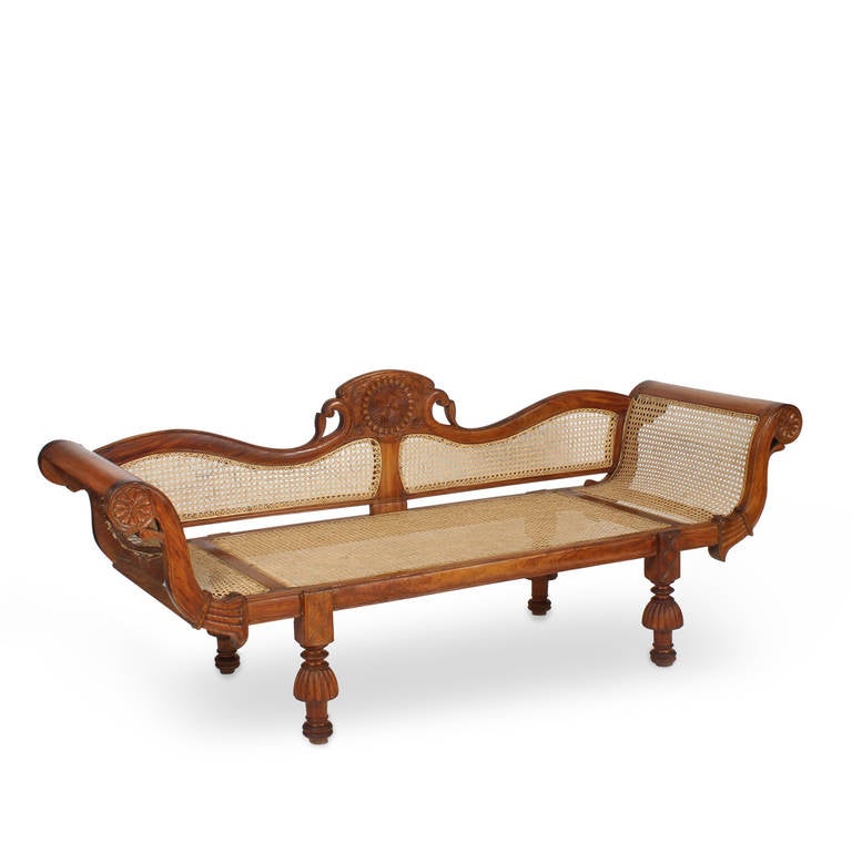 What captures the imagination more the West Indies, especially the British Colonial period? We are excited to offer an early West Indian caned settee or sofa having rolled arms, bulbous legs, turned feet and carved crest, all in a tropical hardwood.