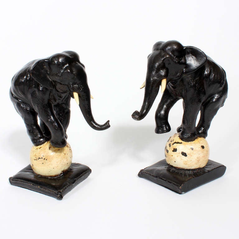 A pair of delightful painted cast bookends by Armor Bronze.
Circus elephants balancing on balls on fringed edged pillows. 
Very fanciful.