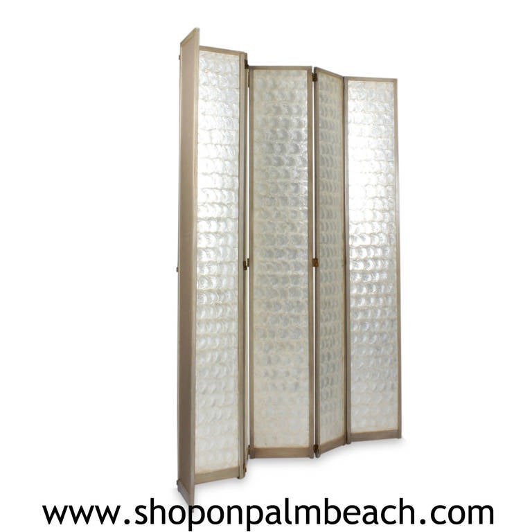A glowing, vintage six-panel screen or room divider, the front covered in luminous and thick capiz shell veneer, the back done in a neutral fabric. Frame painted in continental grey. We have never seen one before. A very dramatic and light catching
