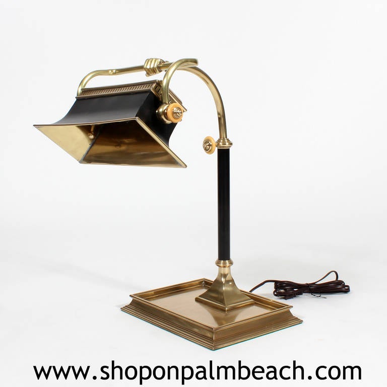 Brass desk lamp in an Empire manner labelled chapman. Handsome and stately with an accent of celluloid and the whimsy of a folk art human hand holding up the shade. The black patinated brass shade is adjustable. Newly wired.

 