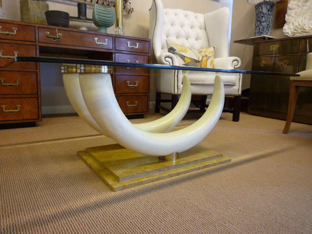A well made Mid-Century Modern chic faux elephant tusk table with brass details and stepped marble base. The bevelled glass has a discreet etching to the edge of glass, not visible to the camera lens. Attributed to Maison Jansen.


