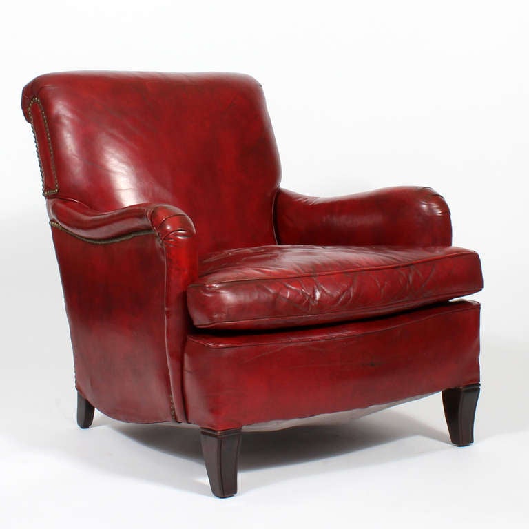 Pipe, wide brimmed hat, slippers by the chair, just a few images evoked by looking at this wonderful red leather chair. Great red color, with a wonderful flow to the arms, highlighted with brass nail heads, a slight kick to the foot, a roll to the