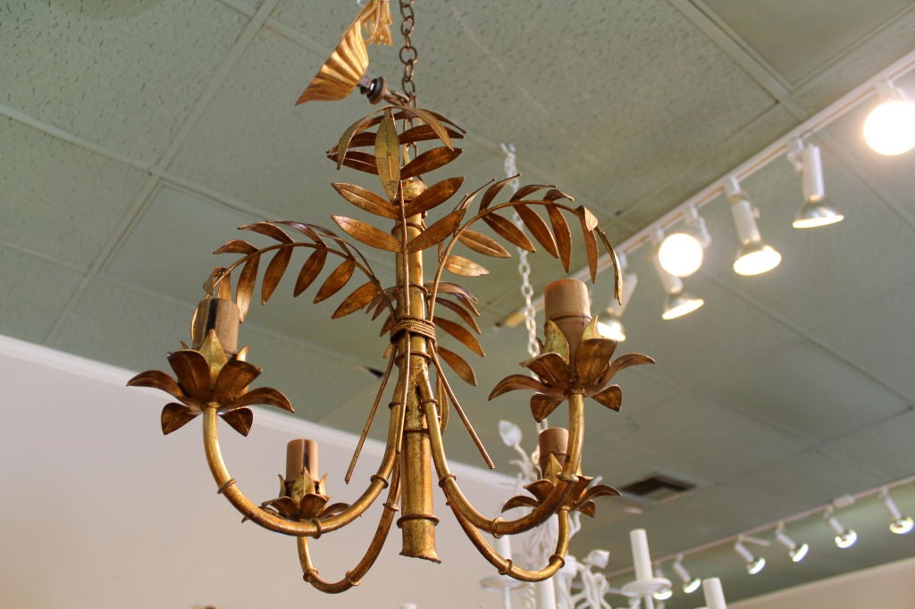 An Italian gilt metal 4 arm chandelier, with faux bamboo shaft and arms, and stylized palm tree fronds/bamboo leaves.<br />
<br />
Please check out our website at fshenemaderantiques.com