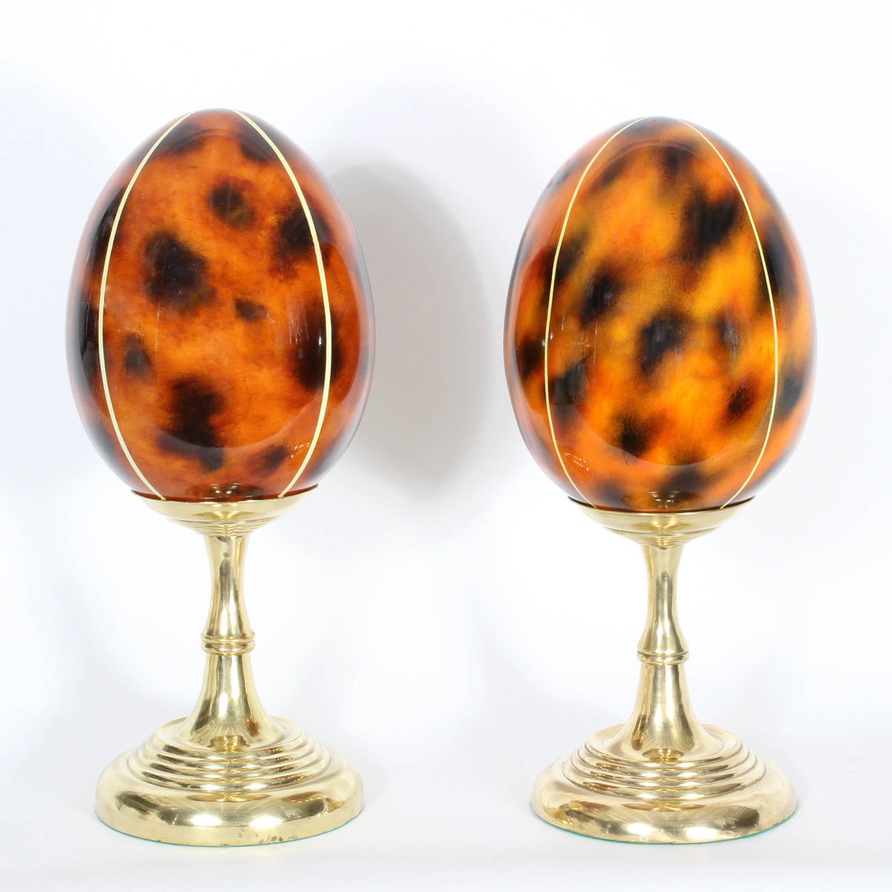 A pair of faux tortoise lacquered egg shaped objects de arte on solid brass turned pedestals, with a candlestick vibe. No home is complete without them.
Possibly by Maitland - Smith. Newly polished.

 