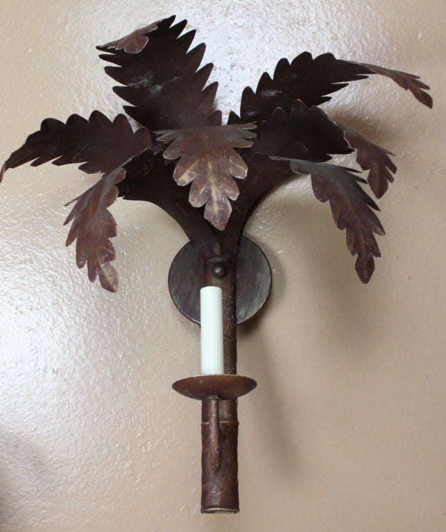 A pair of newly wired patinated iron palm tree wall sconces. We have 4 of these sconces available.<br />
<br />
Please check out our website at fshenemaderantiques.com
