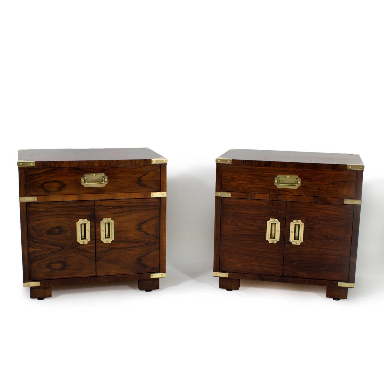 In the mid-20th century, John Stuart designed a line of high quality campaign furniture, with modern flair, based on classic lines and tropical hard woods, This is a pair of labelled nightstands from that line. Rosewood. Newly polished.

 