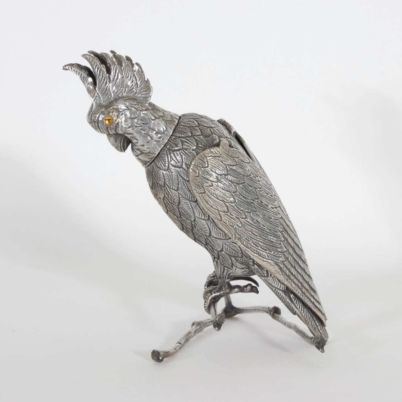 Silvered metal parrot with hinged wings, glass eyes and removable head for secret storage.  An intriguing object of interest with history we can only guess at. Beautiful to the eye, and practical for use as a box or container.

