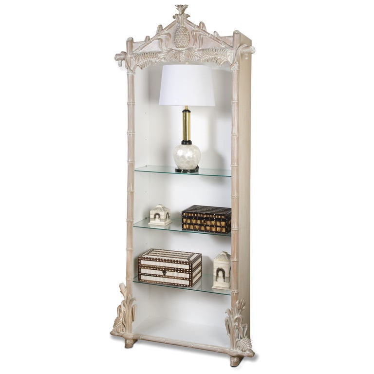 A pair of white washed display cupboards or shelves, with white painted interiors, glass shelves carved pineapples and ferns with faux bamboo surrounding the openings. Lighting receptacle is recessed into the top of the cupboard, if you like your