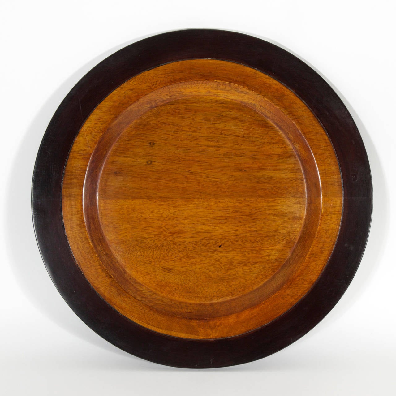A set six mahogany charger or service plates with ebonized borders. Set a warm tropical mood to an intimate lunch or dinner. Newly polished.