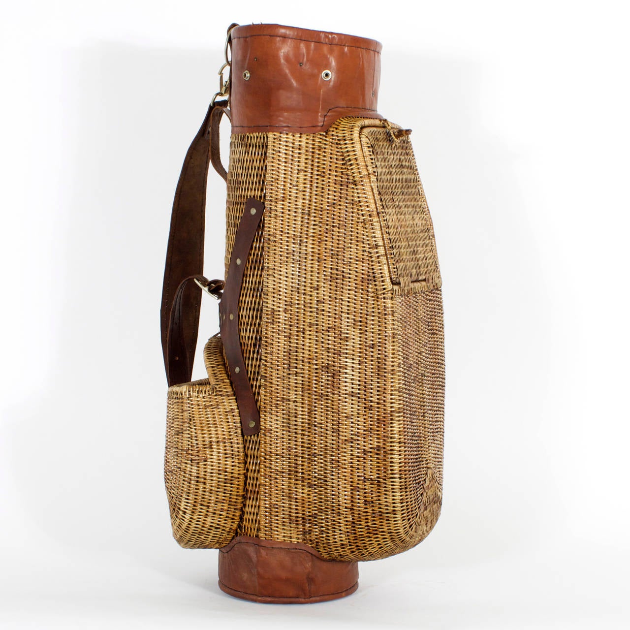 Vintage wicker golf bag ripe with patina. Featuring woven wicker lidded compartment and leather accents and straps. All you need is knickers and high socks. A must have for the coolest of golfers.