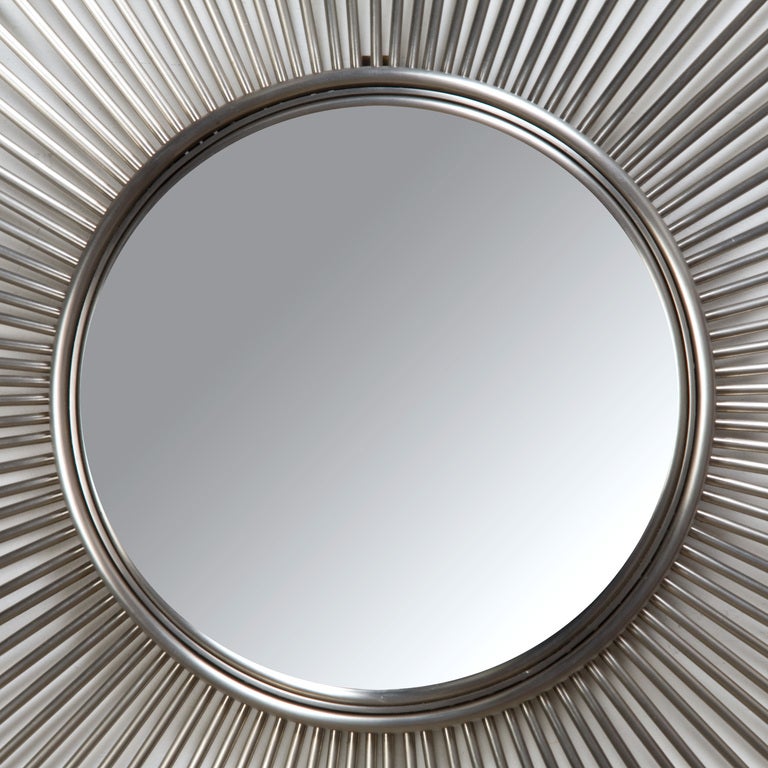 A large stainless steel or aluminum sunburst mirror with thin radiating rays, and a slight convex mirror. Neat and precise, this large mirror has a great presence.

fshenemaderantiques.com for all things decorative.