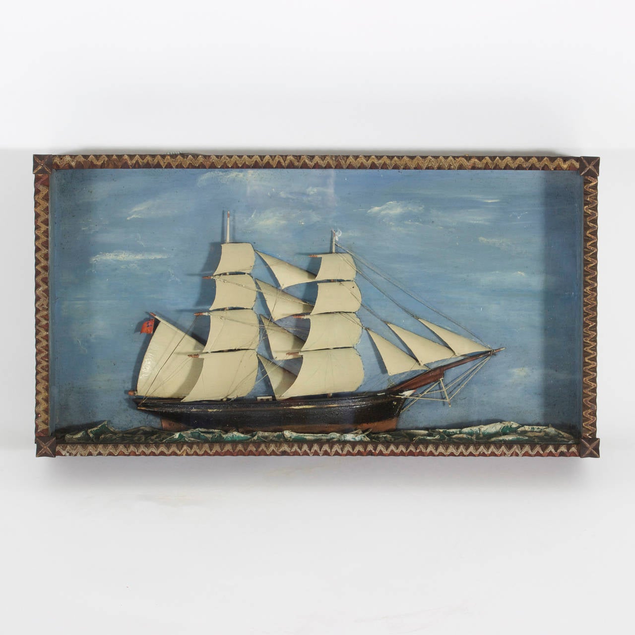 Folky diorama of an English sailing ship complete with sails and rigging, flying the Union Jack and presented in a charming handmade case .