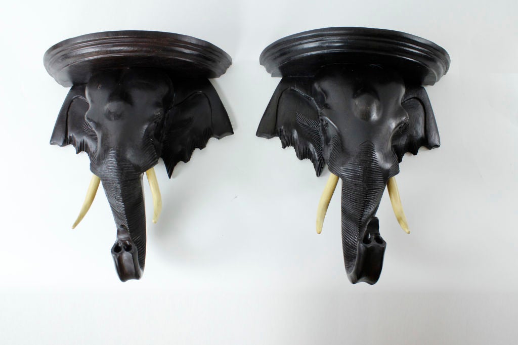 A pair of carved teak  elephant wall brackets or sconces.  Beautiful finish, with a great look on the wall.