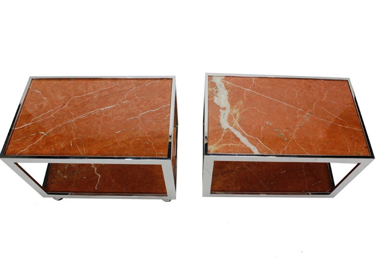 A pair of chrome and marble side tables, with marble shelves, and rolling castors for easy moving. Beautiful color and veining to the marble.
 