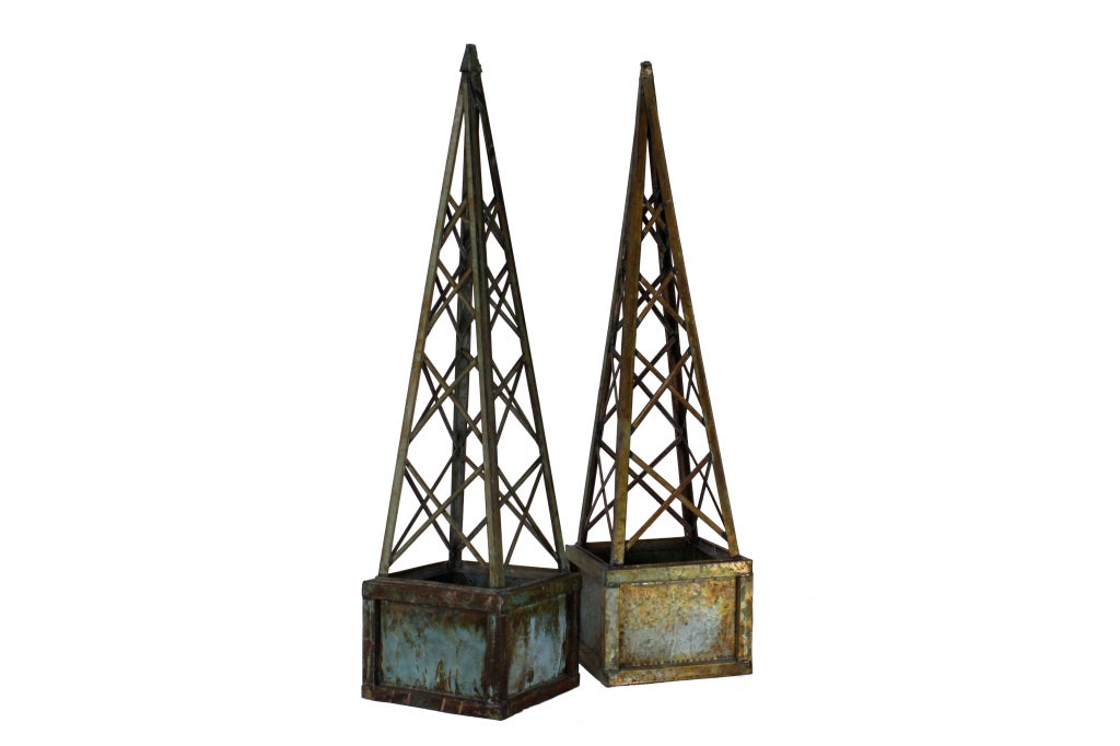 A pair of faux copper verdigris hand made galvanized metal trellis planters, in the shape of obelisks. Very tall and stylish with a fabulous finish. The tops lift off for ease of planting.
Plants or not, these trellis planters, are super