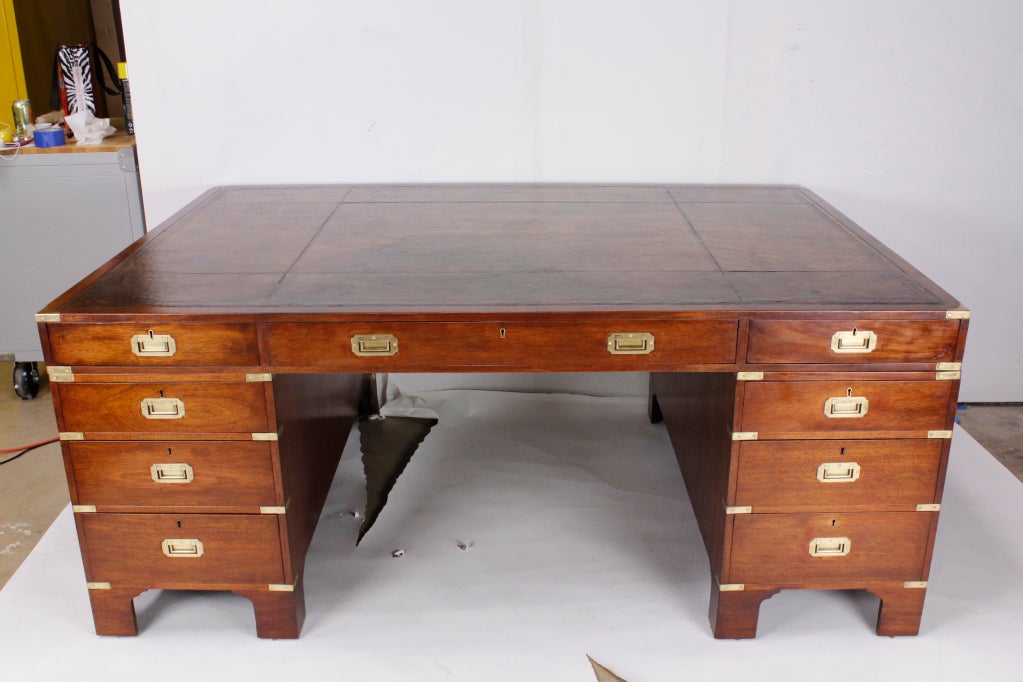 Mahogany campaign style partners desk, with bracket base. The partners desk has functioning drawers on one side and faux drawers on the other. Multi paneled tooled leather top. Beautiful piece of furniture. Impressive and functional.

Looking for