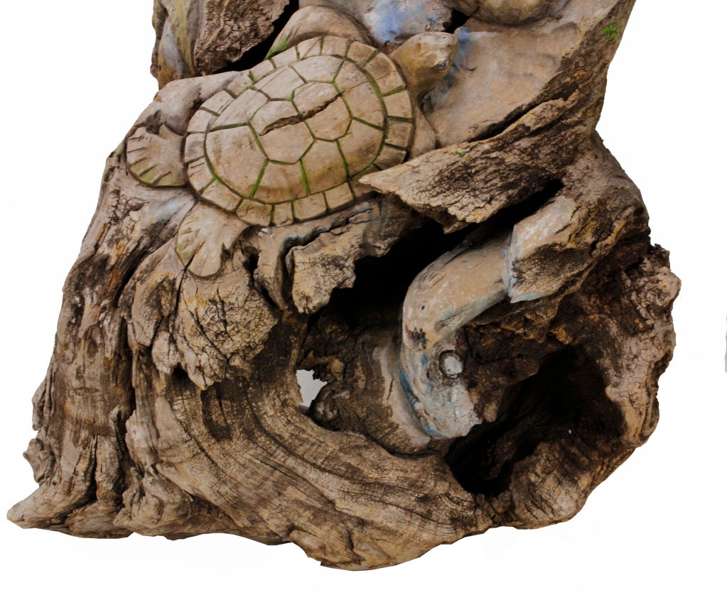 A large driftwood sculpture depicting the intricacies of the coral reef, seahorse, starfish, crab, eel, fish and turtle carvings come to life as the sculpture slowly reveals itself. Paint remnants highlight the carved sea life, embedded in the nooks