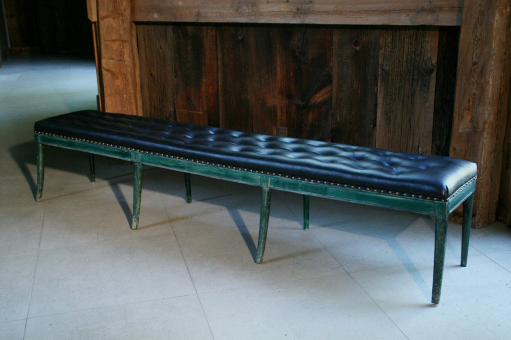 A rare and original 7' long bench designed and hand painted by Tony Duquette, c.1961. The sabre legged frame was hand painted in Duquette's signature malachite green, with original black vinyl tufted seat, and brass studs bordering around entire