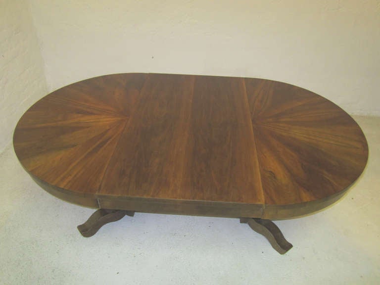This round table with its strikingly figured walnut veneer is supported by a split column on four scrolls. Extended with one leaf it can seat six to eight comfortably.

Leaf size: 49