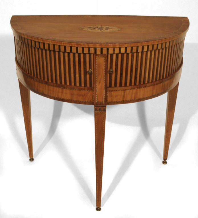 Ingenuity and craftsmanship abound in this delicate console table with tambour doors. The alternating vertical veneer strips are set into tracks, which slide right and left to reveal a compartment inside. Tapered legs with sabots add to the light