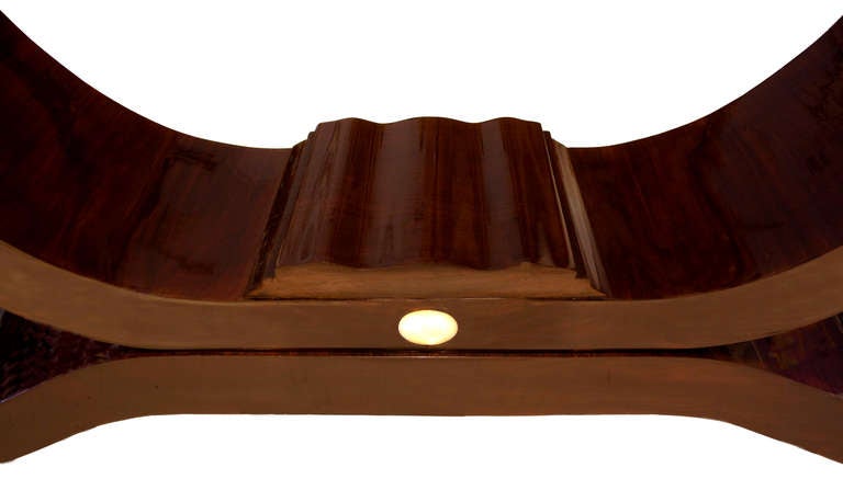 A gracefully curved base meets a rectangular top with an elegant
detailed edge. The oval-shaped mother-of-pearl inlay provides a delicate
contrast to the rosewood veneer.