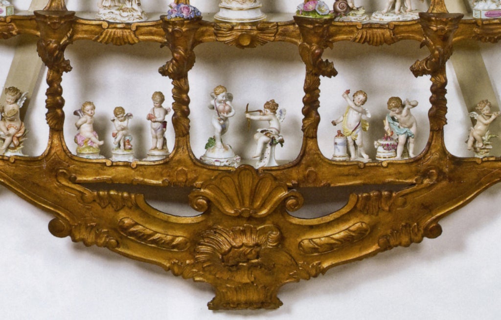 This Rococo wall-mounted gilt limewood étagère was crafted in the 19th century, as were the Meissen porcelain figures pictured in the 15