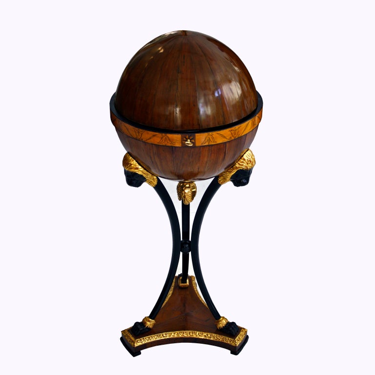 Walnut, Maple, Pearwood | Carved, Gilt, and Ebonized Detailing with Penwork
Featuring a secret drawer, with the original lock and key.

This is one of very few Biedermeier globe tables ever created, most of which are now on display in museums or