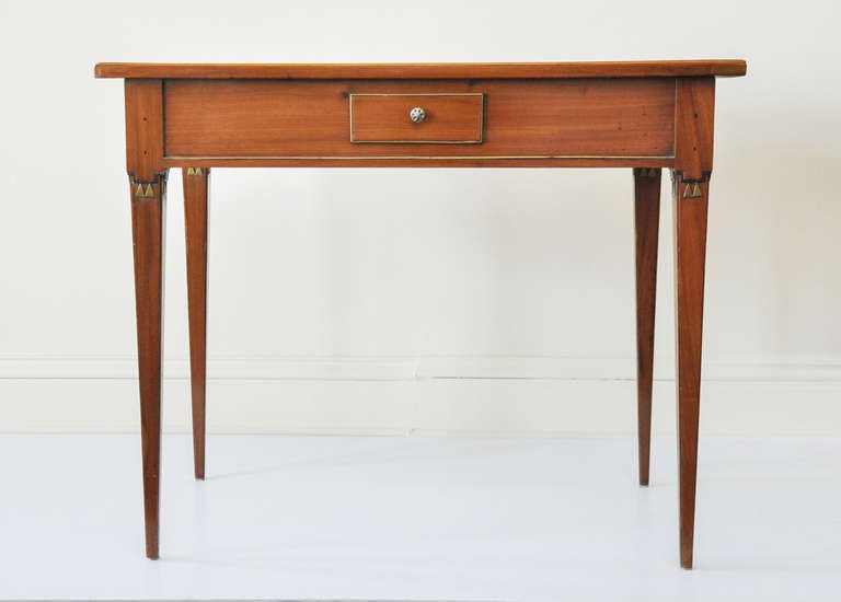 Light mahogany with one brass-detailed drawer on each side. Each leg features triangular brass detailing.

Made in Vienna.