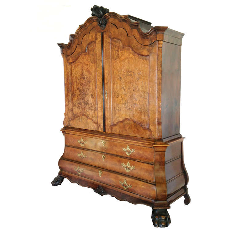 18th century Dutch armoire with burled walnut veneer. This cabinet à deux corps in the Rococo style has a top cabinet with twin-paneled doors and chest of drawers.

Below, the three graduated full drawers with original brass locks and pulls are