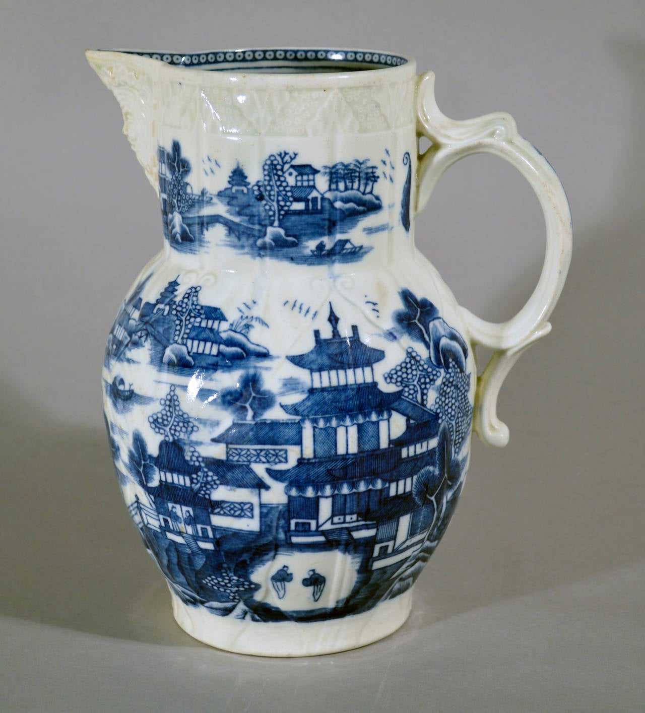 The jug moulded and printed in underglaze blue.  The Conversation pattern is a rare Chinese-style design. It is named after the two small figures in the design who appear to be in conversation. Circa 1780.