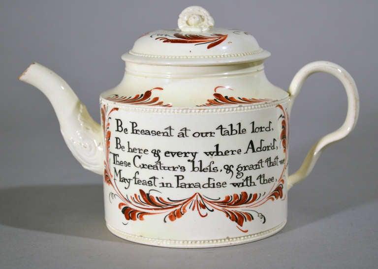The plain creamware teapot is unusually decorated with a panel on each side containing a hand-written prayer for Grace within leafy surrounds in iron-red and black.

We thank thee Lord for this our food,
But more because of Jesus. blood,
Let