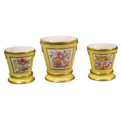 A Garniture of Three Coalport Yellow Cache Pots and Stands