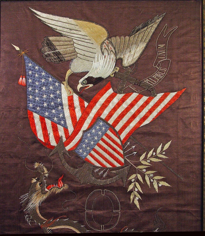 The large silkwork depicts an adaption of the Great Seal- An American Eagle grasping an American Flag which overlaps a large anchor.  A band reading E PLURIBUS UNUM sits behind the anchor.  The whole overlaid with a shield form Stars & Stripes,
