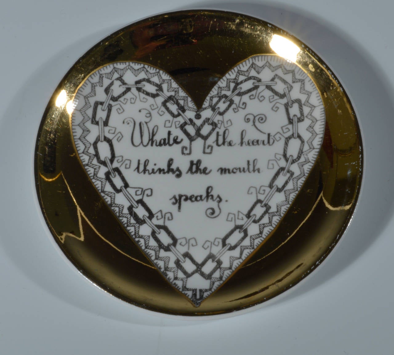 The unusual coasters are in their original red box with a gilt applique heart on the top.  Each coaster has a central white heart on a gold ground.  Within each heart is a saying about love framed by a different heart shaped border

The saying or