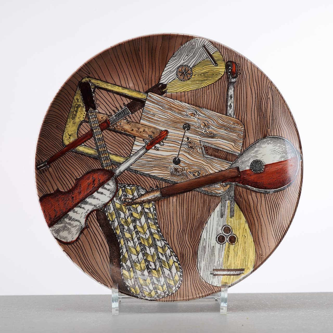 The plates are numbered 1-6, and each depicts a different selection of stringed instruments including guitars and lutes on a faux bois ground. 

Strumenti Musicali translates as Musical Instruments.

Reference: Fornasetti: The Complete Universe,