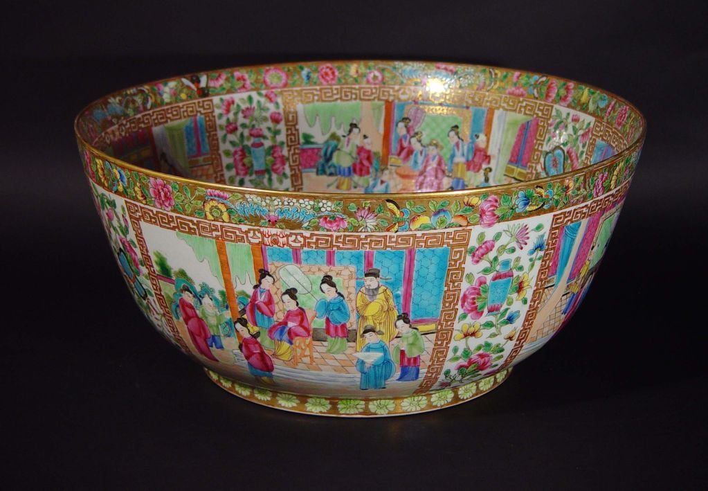 The beautiful bowl with unusual steep sides is finely painted all over in a rose canton famille rose design.  The outside has five large panels painted with garden and interior scenes peopled with men, women and children.  Each panel has a large