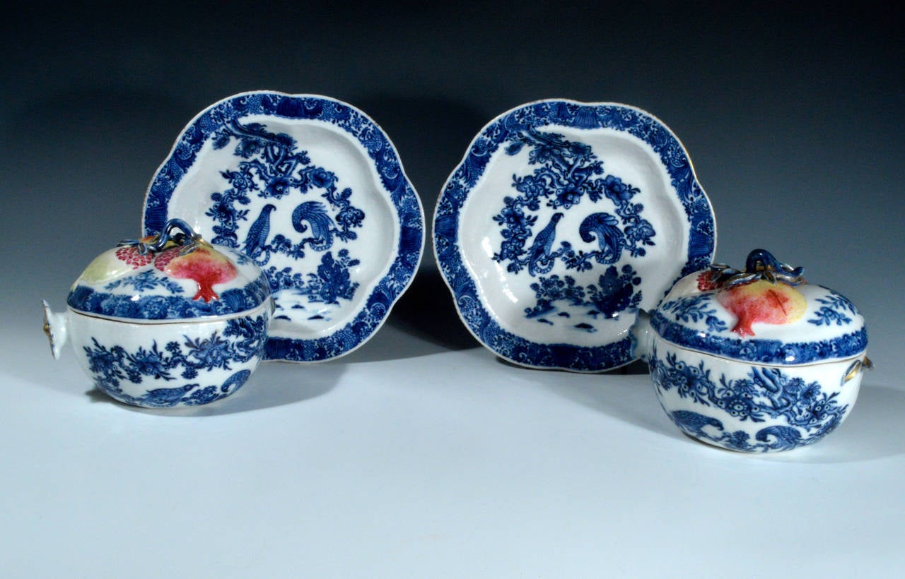 The trompe l'oeil Chinese export covered tureens are moulded in the form of pomegranates on stands. Each tureen has a cover with three famille rose ripe pomegranates, the body and Stand each decorated in underglaze blue with two parrots facing