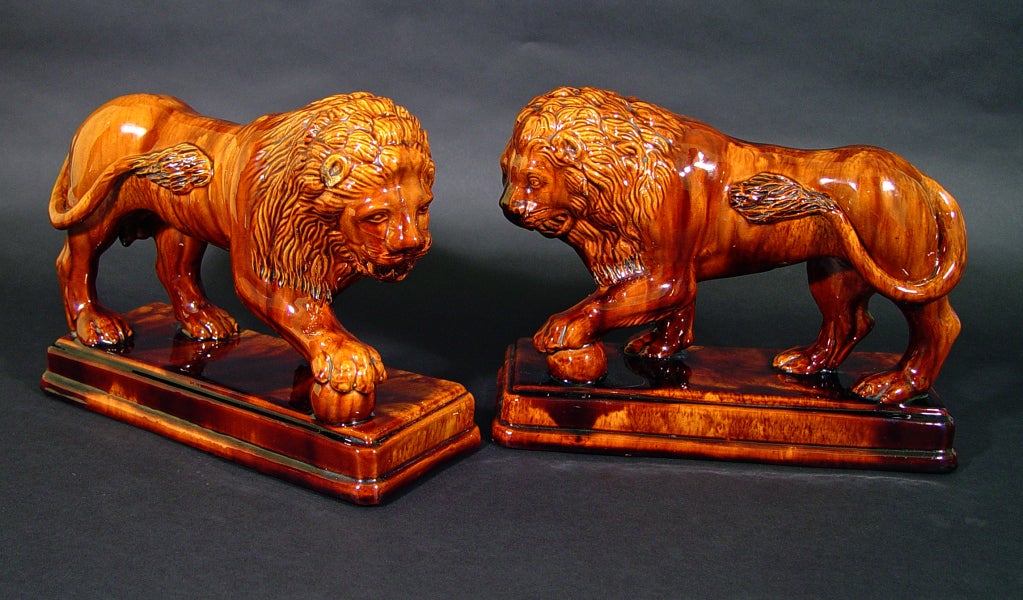 Fenton's Enamel, Bennington, Vermont,

The lions which are a true pair face each other.  The stand on a stepped base and have a typical brown mottled glaze.