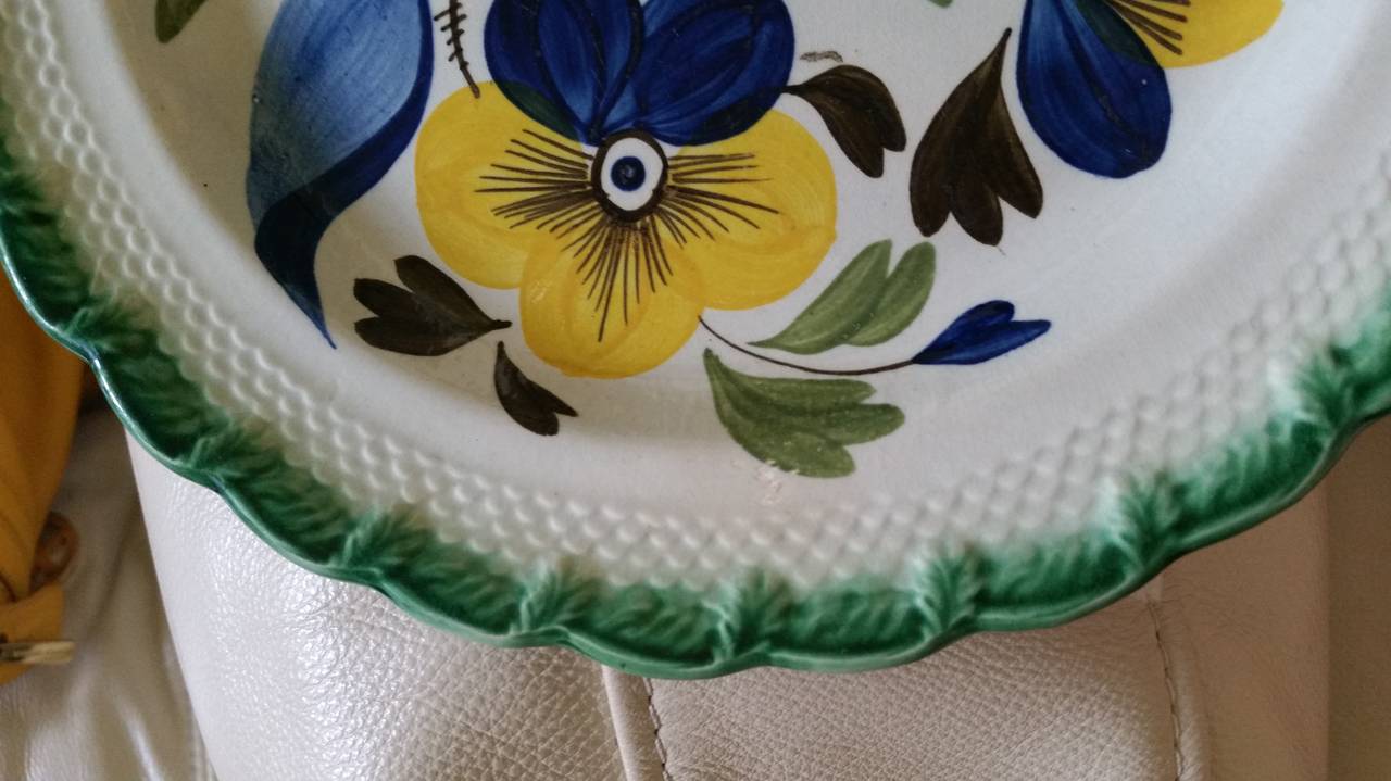 High-temperature Underglaze Colours,

The pearlware plate with a large dramatic central design of a pansy with yellow and blue flower heads on a brown stem with large green leaves.  The border with a moulded fish-scale design and the rim in green