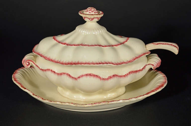 ,
Probably John Turner,
Circa 1785-90.

A rare English creamware sauce tureen with cover, stand and original ladle. The lid features a undulating surface topped by a flower finial. The tureen has scrolled handles and a scallop detail across the