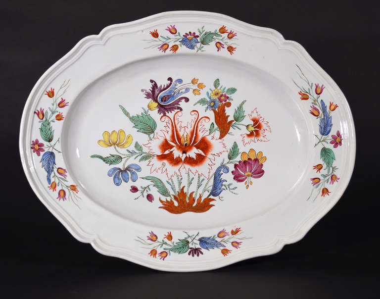 The Doccia porcelain large lobed silver-shape rococo style oval dish is boldly painted with a version of the Tulip pattern with large central famille rose flowers in iron red, green, blue, yellow, and black, the whole with gilt highlights.