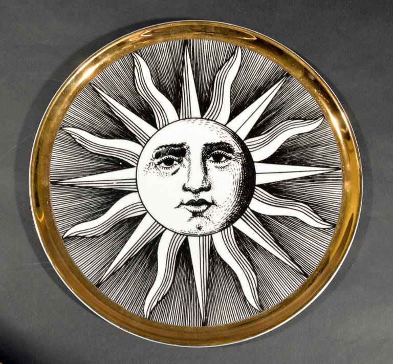 The large dish is decorated with an iconic image of the sun with a gilt border.