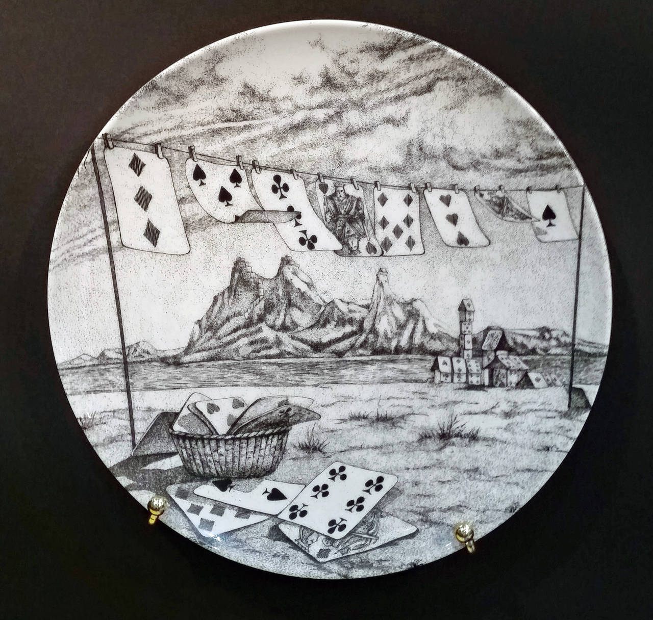 (House of Cards) Pattern 

Each plate, numbered one through twelve, is decorated with a different surreal image of  landscapes or townscapes each with the building composed of playing cards and stacks of cards.

The mark on the base depicts two