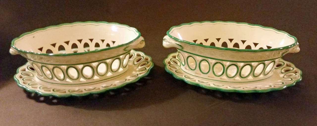The creamware oval openwork baskets and stands are edged in green with each openwork ringed in green too.  The handles similarly coloured are in the form of a dolphin's head. One with small hairline.

Mark: SPODE/40 impressed